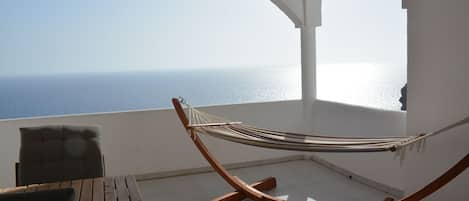 The balcony offers a seating area and a hammock. There is a retractable sunoof