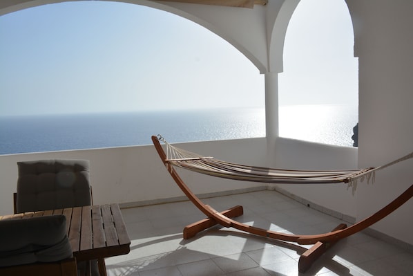 The balcony offers a seating area and a hammock. There is a retractable sunoof