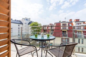 Spacious balcony with outdoor furniture. 