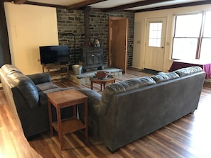 Living area with flat screen tv and wood stove.