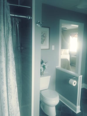 tiled shower in queen suite bath canopied queen bed in background