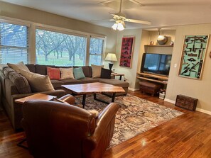 Main living area include large sectional sofa, leather club chair, orchard view