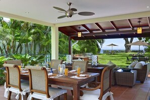 The covered terrace with a comfortable lounge and dining area just steps to the ocean