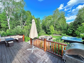 Side of the cabin with sitting area, grill, fire pit and hot tub