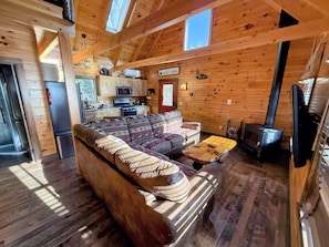 Cabin from front entry with new couch. Small but cozy and comfortable, the main living area includes the kitchen, a small dining table, and a TV area.