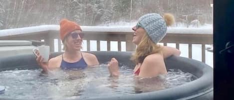 Freelanceadventurer Lindsey enjoying the hot tub on a snowy winter day