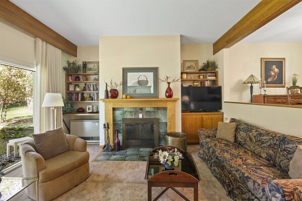 Spacious and comfortable living room with fireplace and flat screen TV