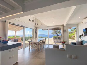 bel espace ouvert cuisine, salon et séjour sur grande terrasse et piscine