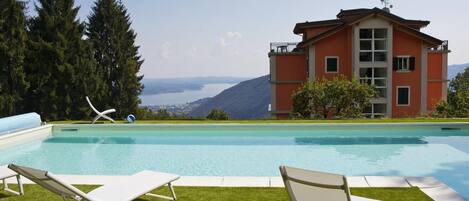 Ca. 11 m x  6 m großer solarbeheizter Pool mit Liegewiese und Panoramasicht auf den See