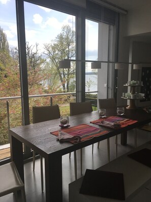 Der Essplatz mit großem Holztisch und Blick auf den See