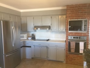 Kitchen with new fridge, hood vent and cook top