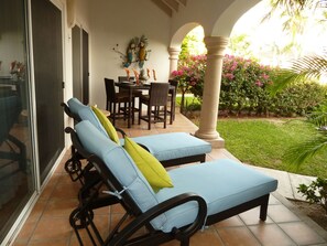Sunny patio with beautiful views of the manicured garden, swimming pool & ocean