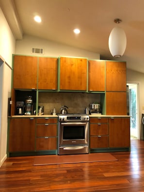 Renovated kitchen has stainless steel appliances & an extra fridge in back