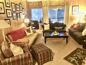 Living room with fireplace, flatscreen smart TV, futon and plenty of seating.