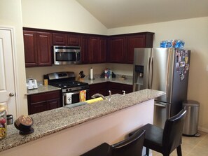 Fully stocked kitchen with extra seating at the bar