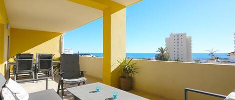 Large terrace facing south with comfortable seating, dining area and sea views