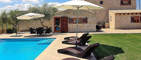 Photo de la maison avec piscine et chaises longues sur la pelouse