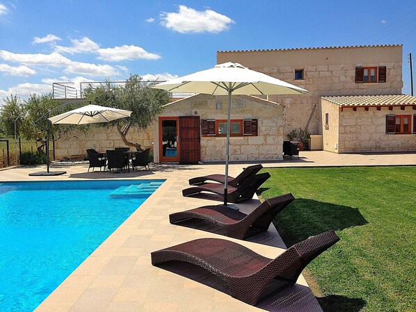 Photo of house with pool and hammocks on the lawn