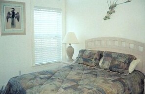 Guest room with queen bed and tropical decor