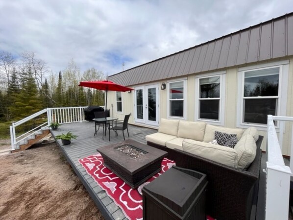 deck facing lake, with patio sectional and propane fire table
