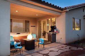 Covered patio with private hot tub, seating and BBQ