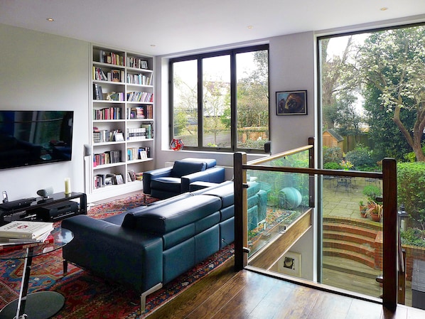 Living area overlooking private garden, large screen TV and hundreds of books!