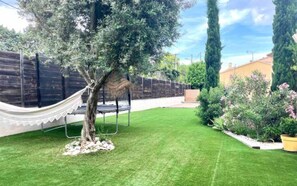 jardin à l'arrière de la maison, trampo, boulodrome et table de ping pong