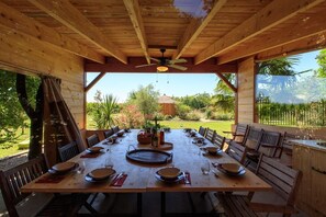 cuisine d'été couverte avec grande table conviviale