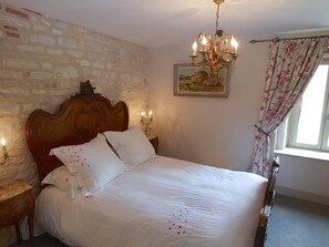 Master bedroom with French linens and antique furniture