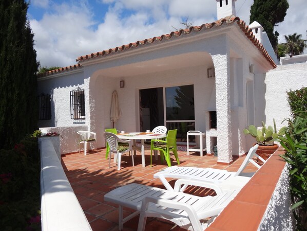 La villa vue de la terrasse avec barbecue intégré .