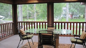 Screened in porch with cushioned seating and hammock (not in photo)