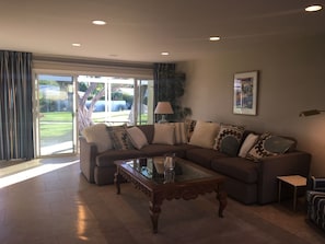 Living room, looking out on common area with pool. 