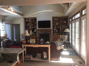 Two story open living room with plenty of windows to enjoy outside.