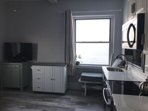 Kitchen island has a drop leaf in the back & there are 2 saddle style stools.