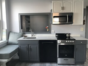Glass top stove/oven with 4 burners, microwave and full-sized Bosch dishwasher.