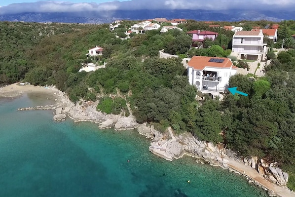 Villa am Meer mit Blick in die Bucht mit Sandstrand; der Pfeil markiert das Ap.1