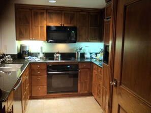 Kitchen with cooktop, oven, micro, dishwasher, fridge & washer/dryer.