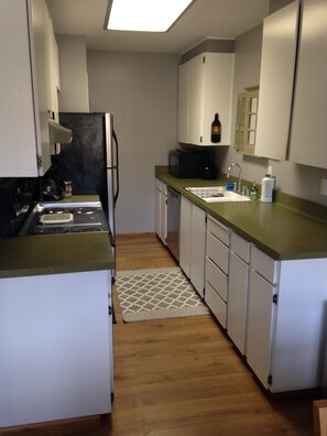 Kitchen stocked with pots, dishwater, utensils
