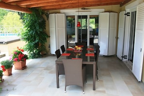 The outside dining area with doors leading into both bedrooms and living-room