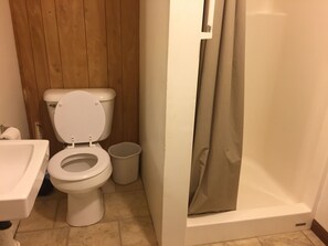 “Line Shack” Bathroom  with toilet, shower, sink, and medicine cabinet mirror.