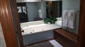 Whirlpool jetted tub, spa bench, and lush towels make for the perfect spa day.