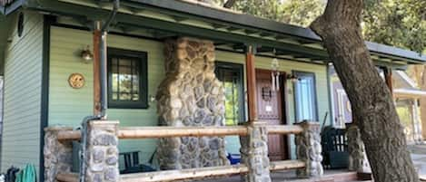 Exterior resembles a log cabin, with a faux stone chimney and log porch railings