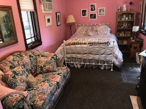 "Gone with the Wind" decor; pink walls, tapestry love seat, white iron queen bed