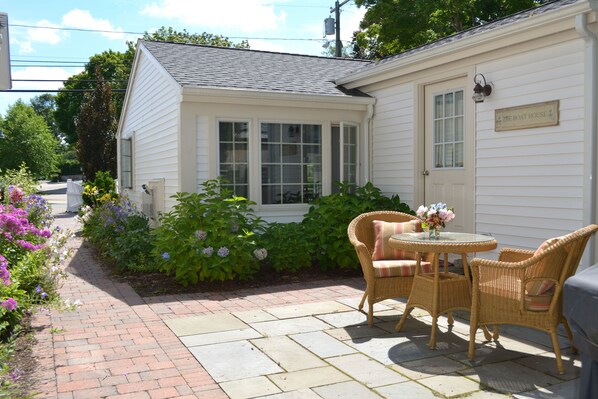 Pathway to cottage and courtyard seating with gas grill.