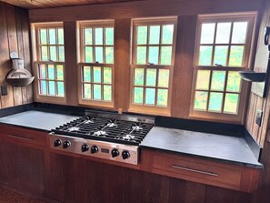 New windows behind the stove allow for summer breezes while cooking!