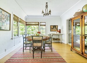 Formal dining room in main house with corner windows that let in warm sunlight