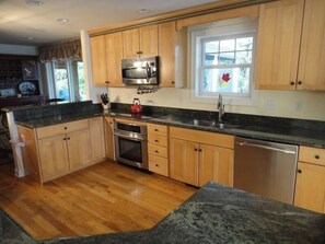 New kitchen with high-end appliances and granite surfaces