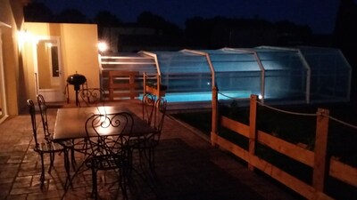 vue de nuit terrasse et piscine avec abri fermé afin de conserver la chaleur 