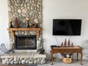 Living room flat screen TV and wood fireplace