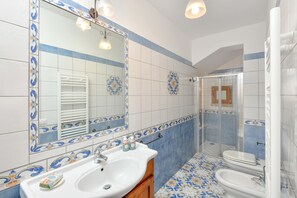 Bathroom with warm coloured tiles with shower and bathrub
